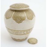 A small Oriental Satsuma style lidded pot and cover, having gilt decoration on a cream ground ,