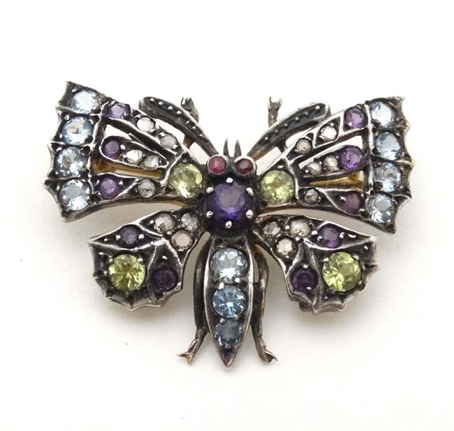 A yellow and white metal brooch formed as a butterfly set with a profusion of stones including