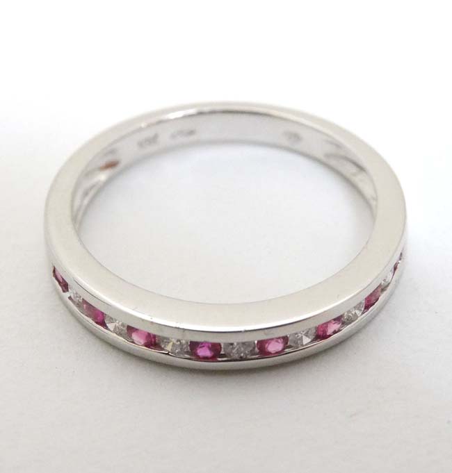 An 18ct white gold diamond and ruby half eternity ring CONDITION: Please Note - we