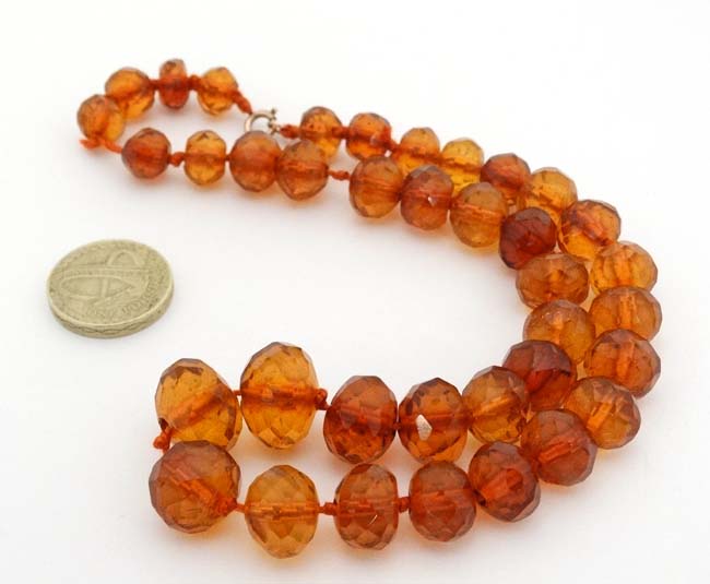 A string of graduated facet cut amber coloured beads. - Image 3 of 3