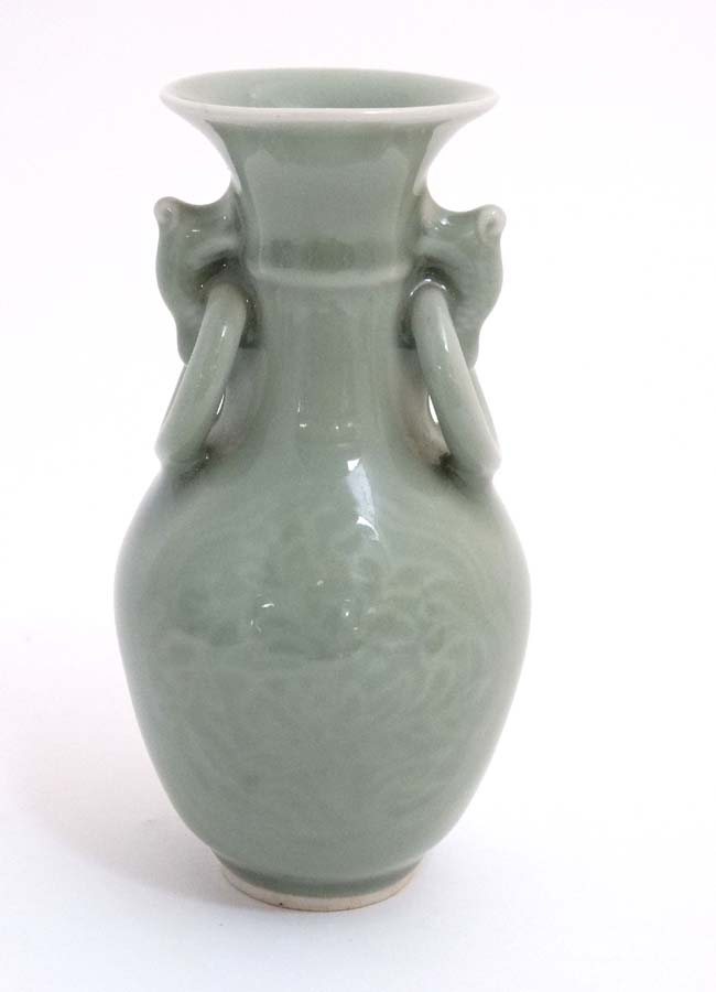 A small Chinese celadon green twin handled bud vase,
