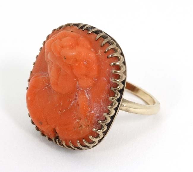 A 14k gold ring set with carved low relief coral cameo to centre CONDITION: Please