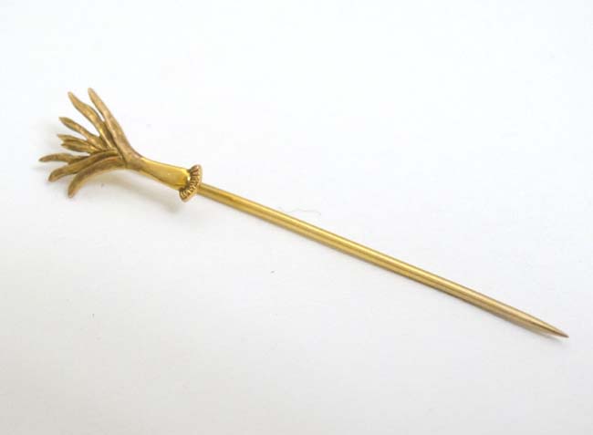 A 9ct gold stick pin surmounted by a leek. Maker J.W.