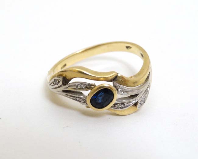 An unusual 18ct gold ring set with central sapphire in a foliate setting with chip set diamonds