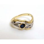 An unusual 18ct gold ring set with central sapphire in a foliate setting with chip set diamonds