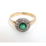 A 15ct gold ring set with central emerald bordered by diamonds CONDITION: Please