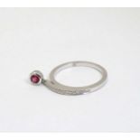 An unusual 18ct white gold ring set with ruby drop and band of diamonds CONDITION: