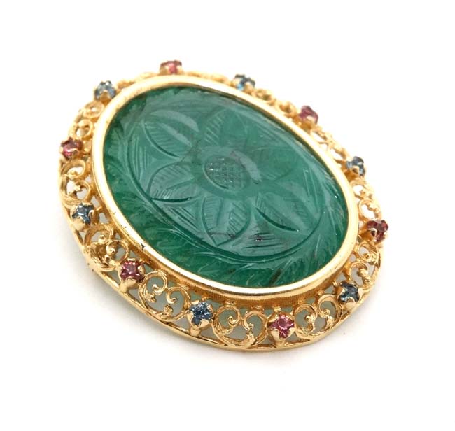 An unusual 18ct gold and gilt metal brooch / pendant having central carved green stone to centre