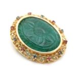 An unusual 18ct gold and gilt metal brooch / pendant having central carved green stone to centre