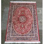 Carpet / Rug : A Machine made woollen carpet , with red central ground, midnight blue,