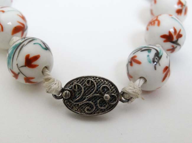 A string of Oriental beads with hand painted decoration and silver clasp. - Image 4 of 4