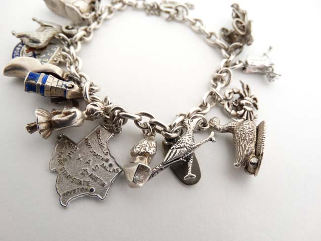 A silver charm bracelet set with 14 various silver and silver plate charms. - Image 2 of 5