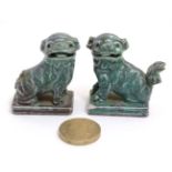 A matched pair of small handed dogs of fo in a celadon green and mottled red finish ,