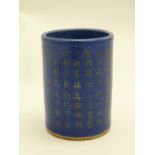 A Chinese blue and gilt coloured brush pot of cylinder form decorated with Chinese script,
