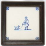 A 19thC Delft tile decorated with image of a young boy with pull along toy horse. Framed.