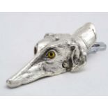 A novelty desk top paper clip / letter clip formed as a dogs head with glass eyes . 21stC.