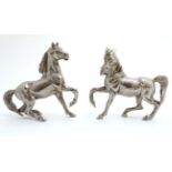 A pair of silverplated handed horses / ponies , standing ,