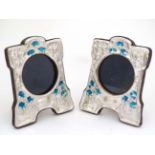A pair of 21stC photograph frames with silver and enamel decorative surrounds in the Art Nouveau