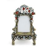 A cast photo frame formed as a an old wooden chair with fruiting vine decoration with green enamel