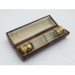 A Victorian double ended glass scent bottle with gilded top. Cased. Approx.