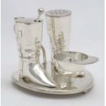 A novelty silver plate cruet comprising pepper and mustard pots formed as riding boots and the salt