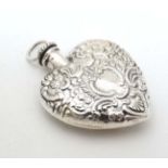 A silver heart shaped miniature perfume bottle. Marked Sterling.