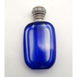 A glass scent bottle, the blue and clear glass body with white metal top.