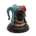 A decorative cold painted bronze novelty inkwell formed as the head of a pug dog wearing a jester