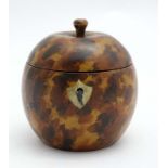 A Folk Art treen tea caddy formed as stylised apple, with painted faux tortoiseshell decoration.