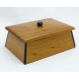 A cedar wood jewellery box with ebony inlay and hinged lid opening to reveal a mirror within.