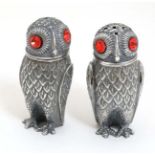 A pair of novelty white metal pepperettes formed as owls with red glass eyes.