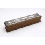 An early 20thC oak jewellery box of slim rectangular form with silk lined interior and having