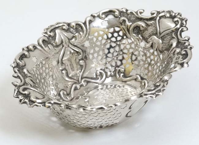 A silver bon bon dish with pierced and embossed decoration.