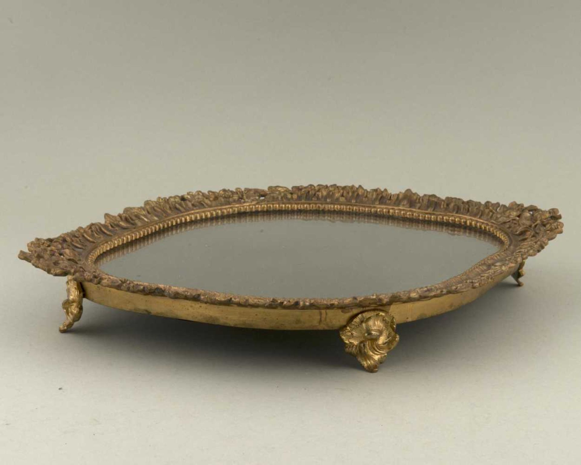 présentoir sur pied mouvementé à bordure en bronze doré à décor de fleurs et plateau en miroir. H.