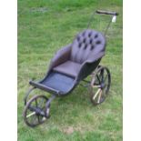 *A Tricycle Pushchair for a Child, late Victorian, having a brown leather padded seat mounted on a