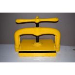 *Bookpress. A cast iron bookpress, finished in yellow, platen approximately 38 x 25cm (15 x 9.75