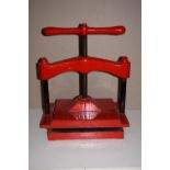 *Bookpress. A small cast iron bookpress, finished in red, with painted wood upper platen, platen