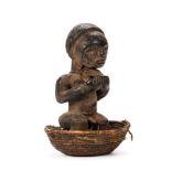 *Figure. A Fang tribe religious figure carved as a squatting tribesman standing in woven bowl,