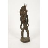 PAPUA NEW GUINEA: A standing tribal figure, the elongated face with cowry eyes, feather hair and