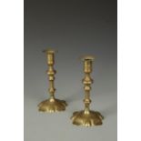 A PAIR OF GEORGE II BRASS PETAL BASED CANDLESTICKS, 18th century, 8.5" high