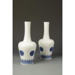 A PAIR OF CHINESE BLUE AND WHITE BOTTLE VASES decorated with roundels, the bases with Kangxi