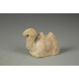 A CHINESE POTTERY BACTRIAN CAMEL recumbent with its head raised, Han, 4.5" long