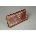 A GILT TOOLED RED LEATHER "POCKET BOOK NECESSAIRE", possibly late 18th century