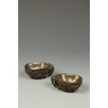 A PAIR OF CHINESE HARDWOOD LIBATION CUPS of flower-form, carved with further flowerheads and