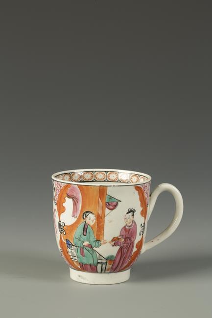 A WORCESTER COFFEE CUP painted in Chinese famille rose style with figures on terraces, within puce