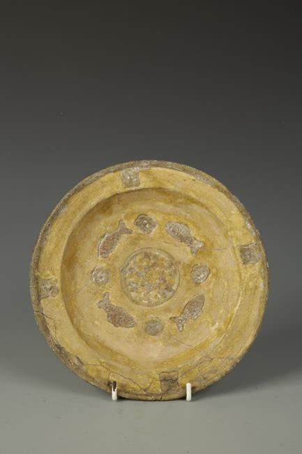 A CHINESE SANCAI TRIPOD DISH, the centre decorated with fish surrounding a flowerhead, Tang, 8"