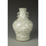 A CHINESE CELADON BALUSTER VASE decorated in slip with birds amongst foliage, Qing, 11.25" high