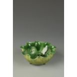 A CHINESE GREEN-GLAZED LOTUS-FORM BOWL, the centre modelled with a frog, late Qing, 6" across