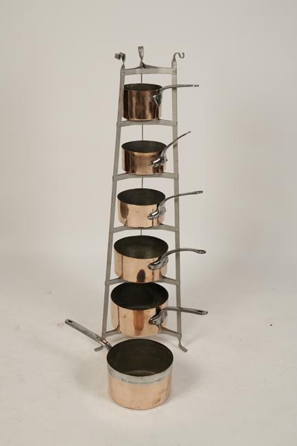 A VICTORIAN STYLE GRADUATED POT STAND with six shelves and six copper finished saucepans, 48" high