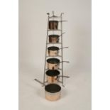 A VICTORIAN STYLE GRADUATED POT STAND with six shelves and six copper finished saucepans, 48" high